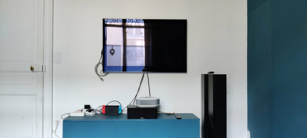 La TV éteinte dans laquelle se reflète la porte-fenêtre